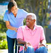 caregiver holding the wheelchair of elderly patient