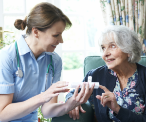 nurse giving senior woman her daily medication